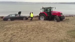 A treia-i cu noroc: Un tractor isi incearca sansele cu un Bentley blocat in nisip