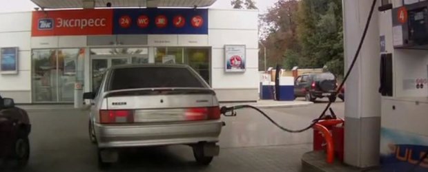 Blonda si pistolul uitat in gura de alimentare cu benzina