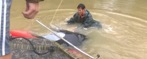 O femeie este salvata in ultima secunda dupa ce masina i-a fost luata de inundatie si scufundata