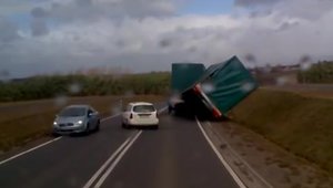 Oamenii fac minuni: O mana de soferi repun pe sosea o remorca luata de vant