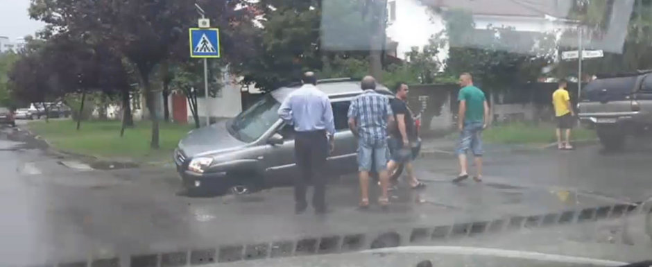 Se intampla in Romania: un sofer a cazut cu masina intr-o groapa din asfalt Se intampla in Romania: un sofer a cazut cu masina intr-o groapa din asfalt