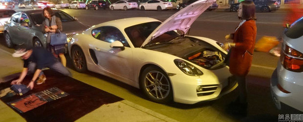 Un chinez cu Porsche vinde esarfe pentru a face rost de bani de benzina